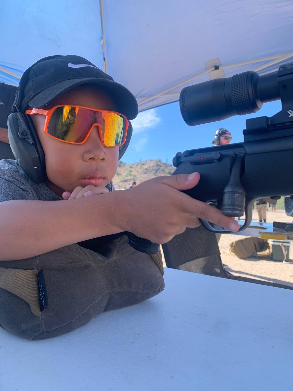 Sovereign King lining up his shot — young shooter learning fundamentals on a suppressed rimfire